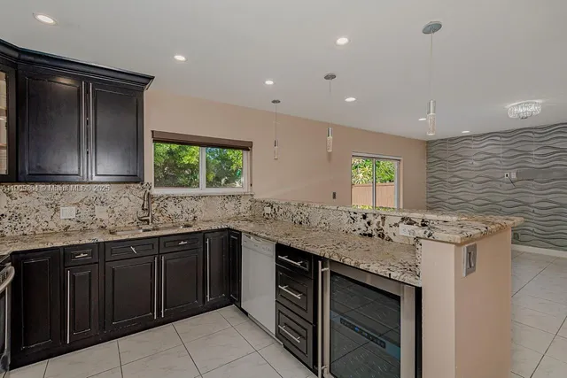 a kitchen with stainless steel appliances granite countertop cabinets sink and window