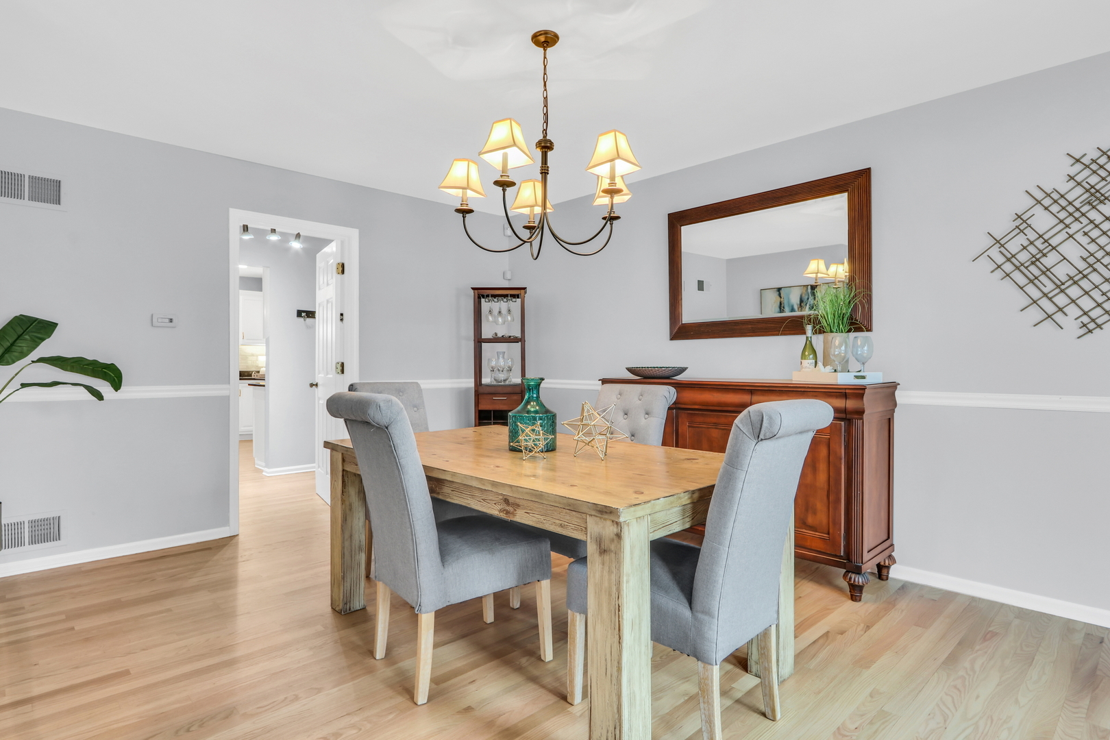 310 Concord Square Gurnee, IL 60031 - Photo 22 of 46 a dining room with wooden floor a chandelier a wooden table and chairs