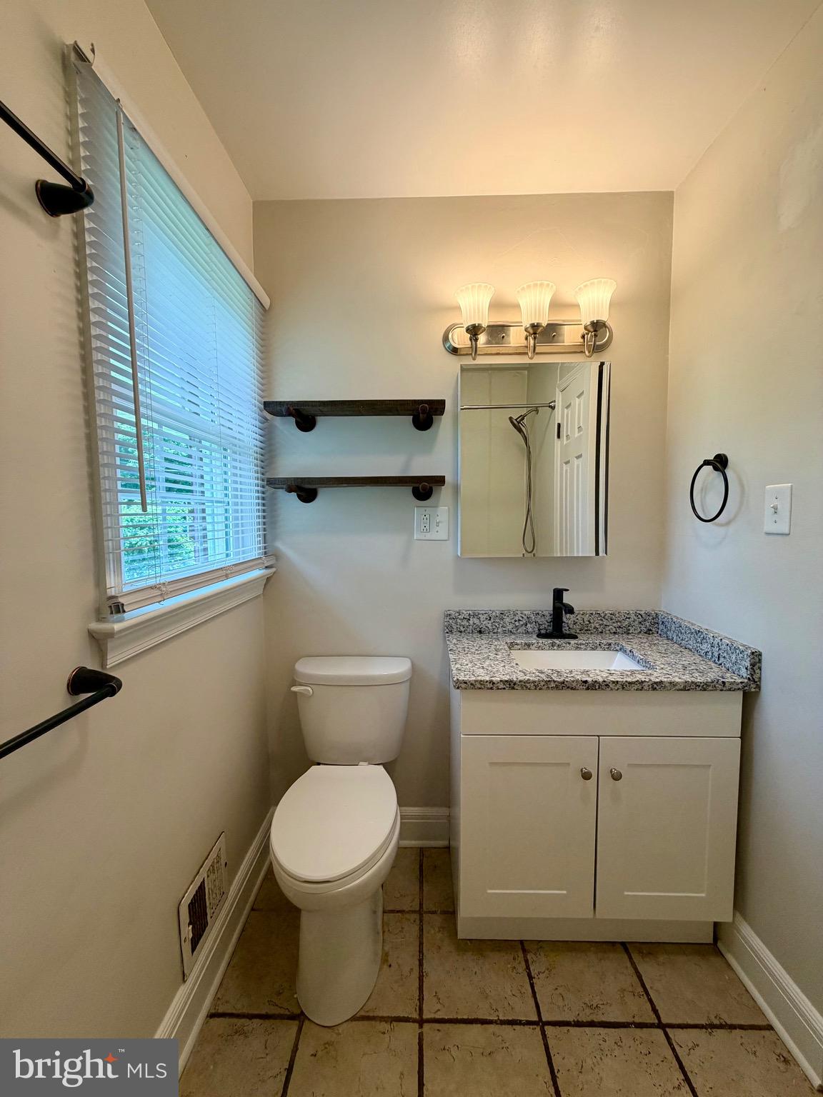 1010 Nottingham Street Culpeper, VA 22701 - Photo 4 of 21 a bathroom with a granite countertop toilet sink and mirror