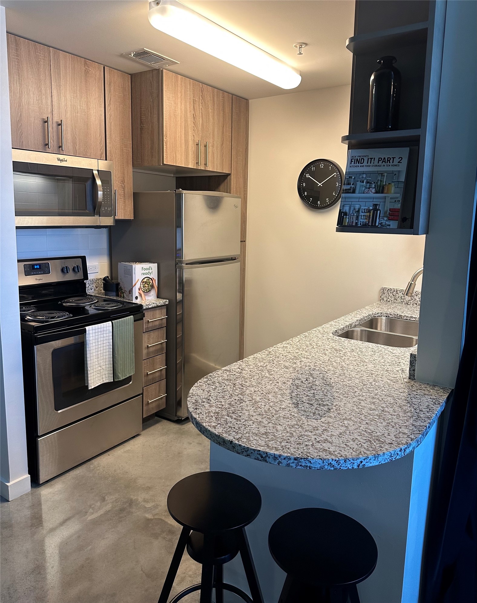 3550 Main Street, Unit 5301 Houston, TX 77002 - Photo 2 of 49 Modern kitchen with stainless steel appliances, wood cabinets, and granite countertops. Includes a breakfast bar with seating, and under-cabinet lighting.