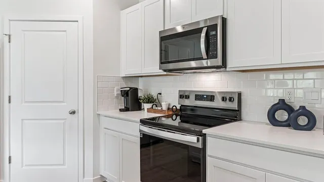 a kitchen with stainless steel appliances granite countertop a stove and a microwave