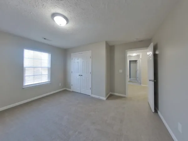 an empty room with windows and closet