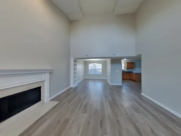 a view of empty room with wooden floor and fireplace