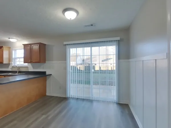 a view of kitchen with wooden floor and electronic appliances