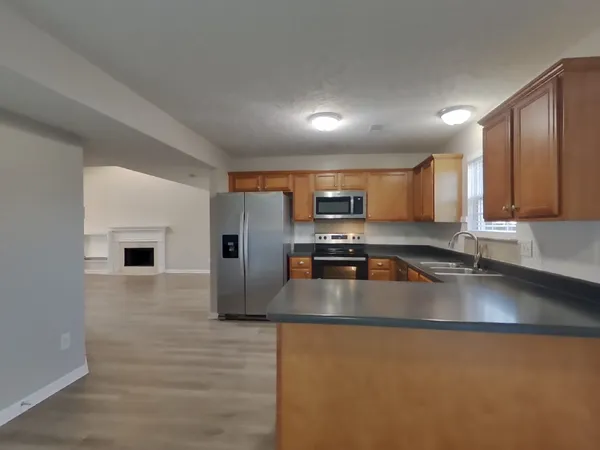 a kitchen with stainless steel appliances granite countertop a sink a stove counter space and cabinets
