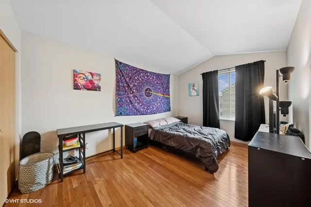 a bedroom with a bed and wooden floor