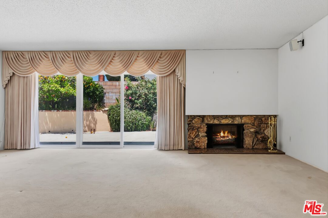 19131 Tulsa Street Porter Ranch, CA 91326 - Photo 7 of 43 a view of an empty room with a fireplace and a floor to ceiling window