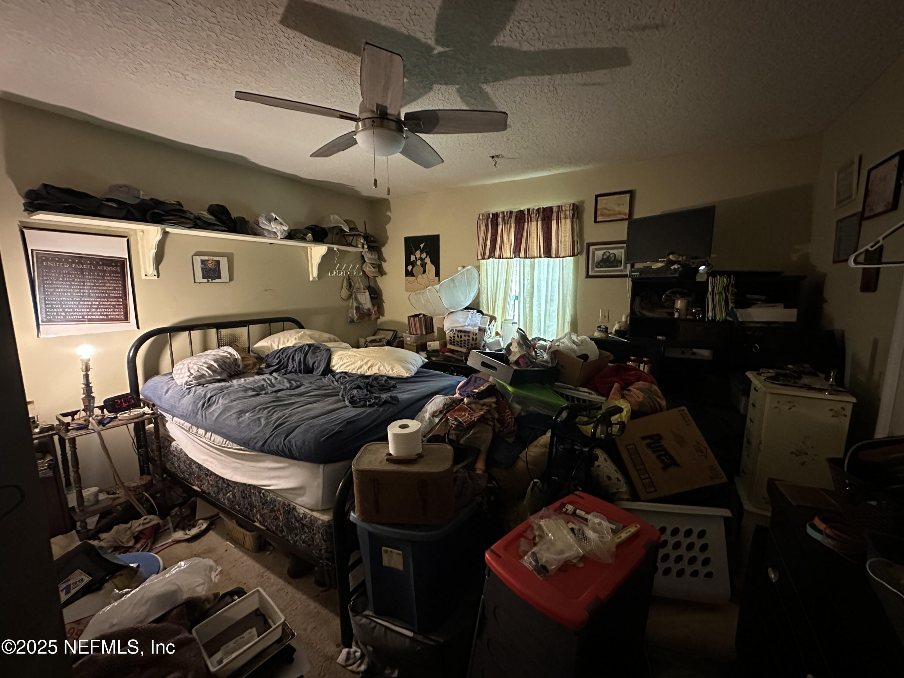 86011 John Street Yulee, FL 32097 - Photo 7 of 18 a bed room with a bed a couch and a ceiling fan