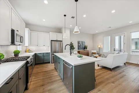 a kitchen that has a sink a counter space appliances and cabinets