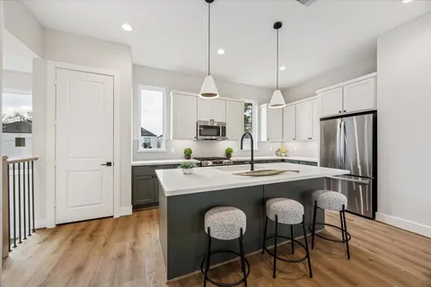 a kitchen with stainless steel appliances granite countertop a center island and a refrigerator