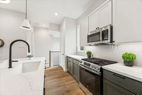a kitchen with stainless steel appliances kitchen island a white stove top oven a sink a counter space and cabinets