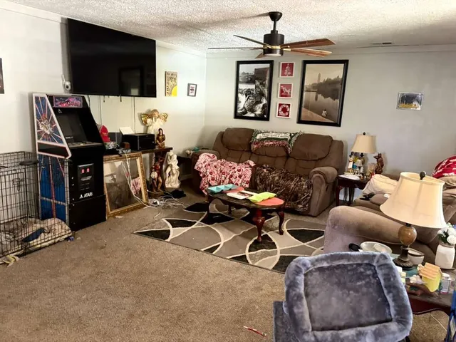 a living room with furniture a flat screen tv and a window