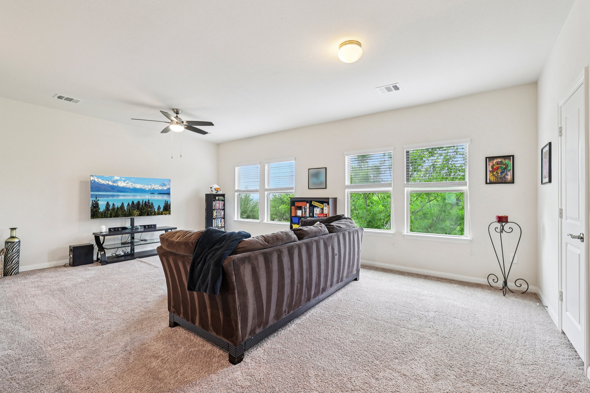 10033 Gertrudis Loop Austin, TX 78747 - Photo 13 of 39 Spacious living area featuring light-colored carpet, a ceiling fan, and windows providing natural light