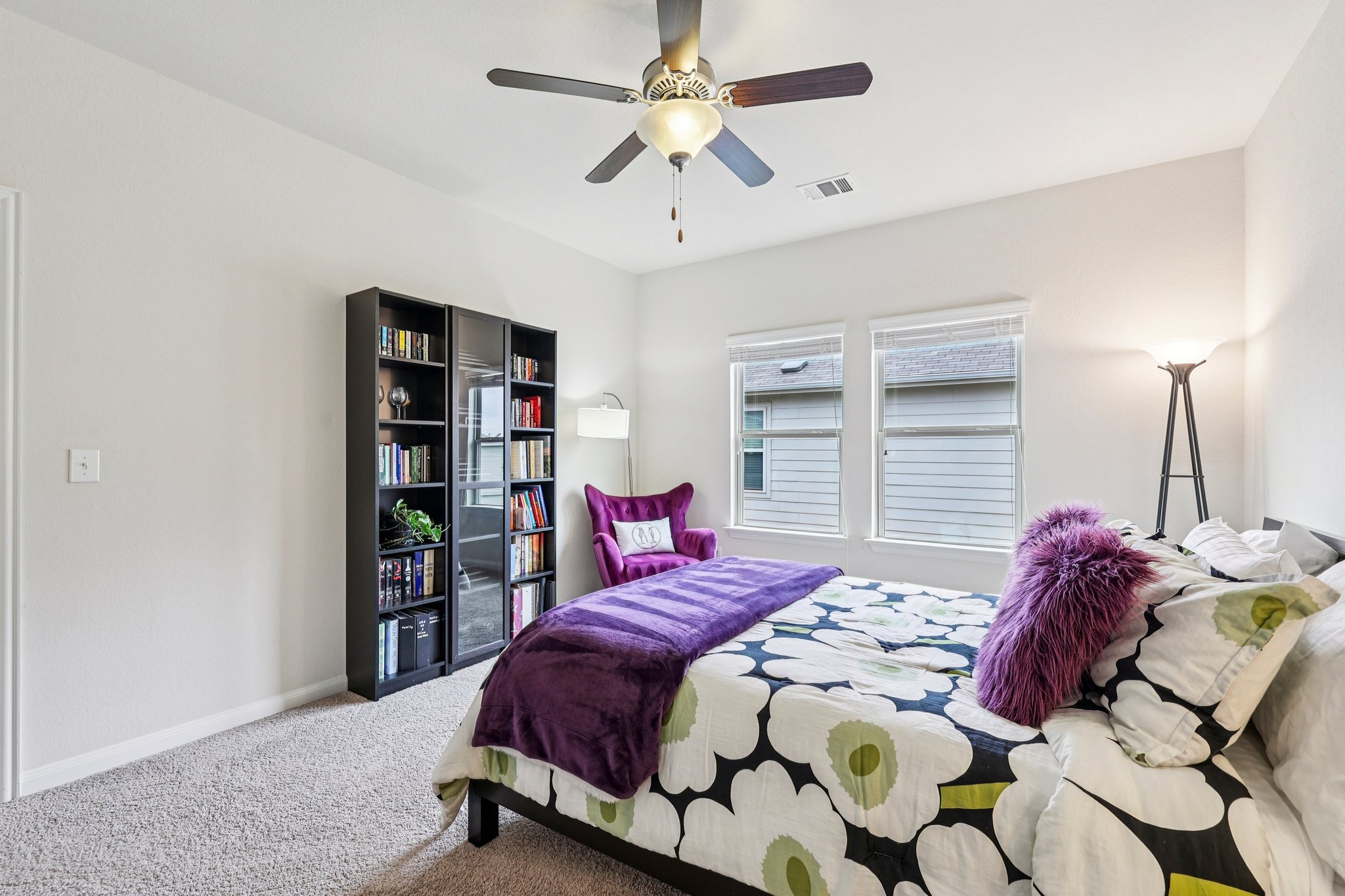 10033 Gertrudis Loop Austin, TX 78747 - Photo 19 of 39 This bedroom features neutral-toned carpet, a ceiling fan with integrated lighting, and two windows providing natural light
