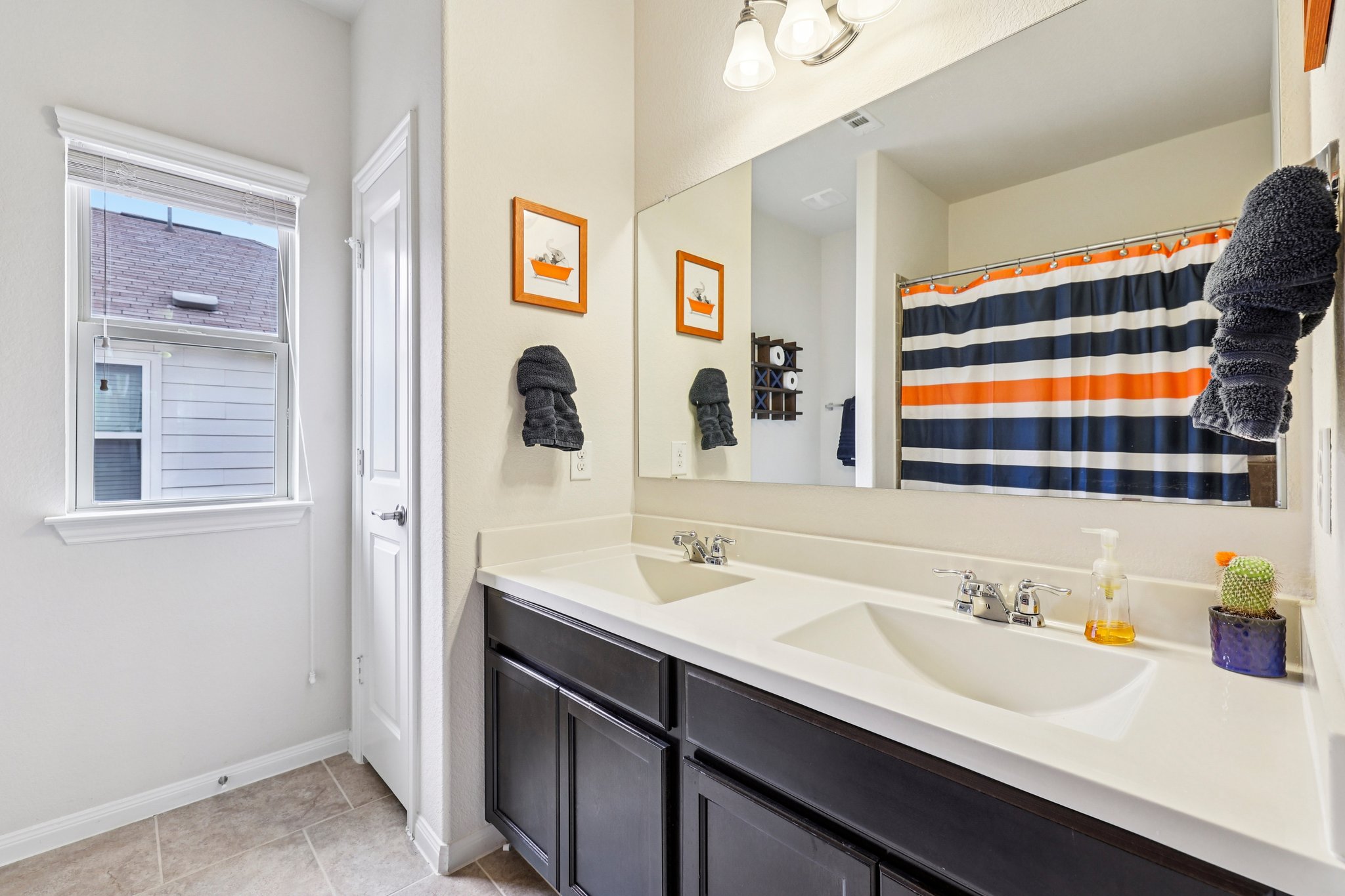 10033 Gertrudis Loop Austin, TX 78747 - Photo 20 of 39 This bathroom features a double vanity with dark cabinetry and light countertops
