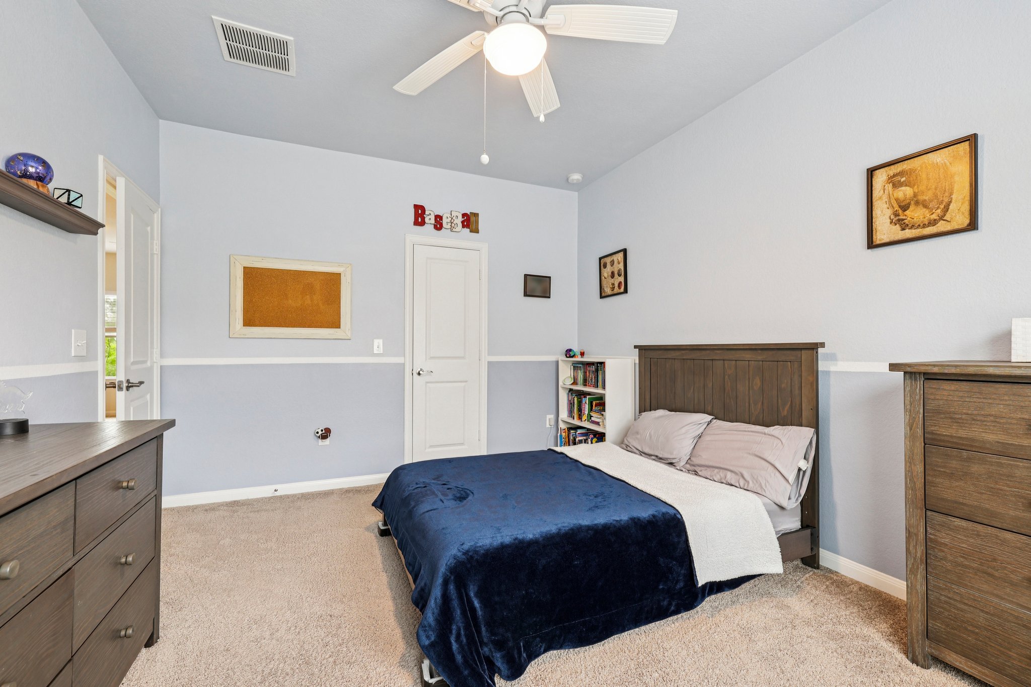 10033 Gertrudis Loop Austin, TX 78747 - Photo 22 of 39 This room features light blue walls with a white chair rail, carpeted flooring, and a ceiling fan with an integrated light fixture