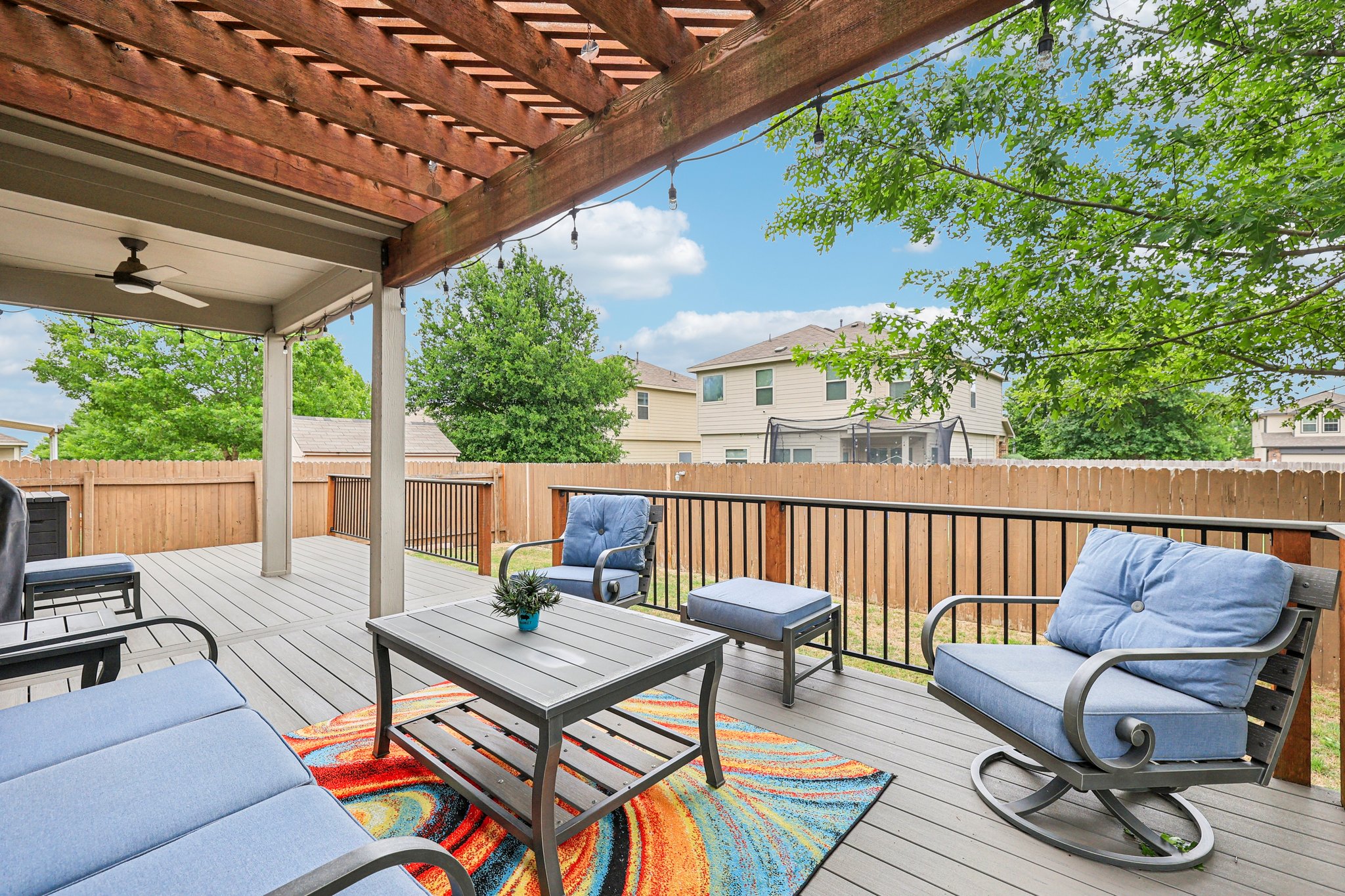 10033 Gertrudis Loop Austin, TX 78747 - Photo 24 of 39 The property features an expansive outdoor deck with a pergola, a ceiling fan, and string lights, providing an ideal setting for relaxation