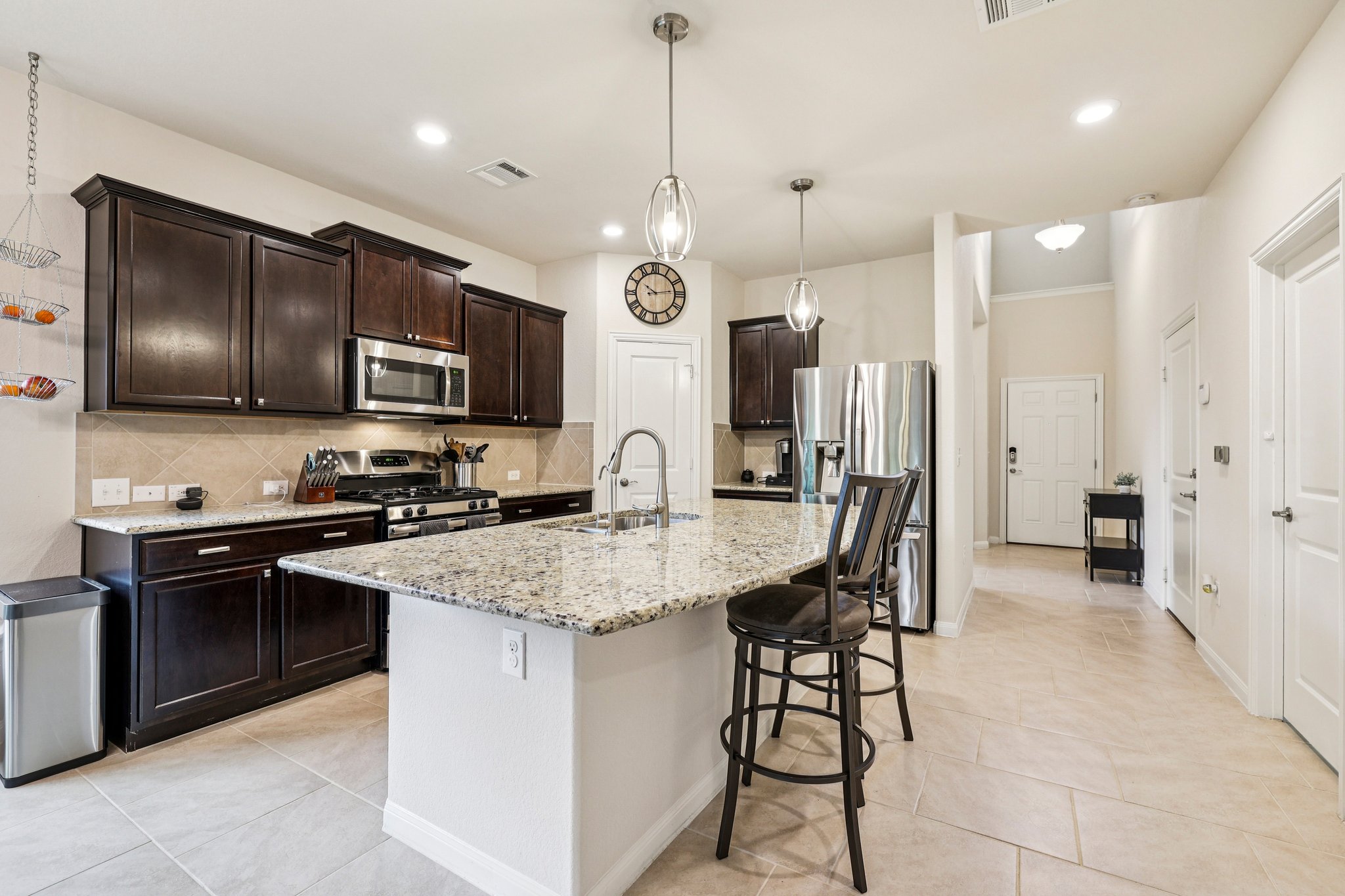 10033 Gertrudis Loop Austin, TX 78747 - Photo 29 of 39 The property features a kitchen with dark wood cabinetry, a stainless steel microwave, and a gas range
