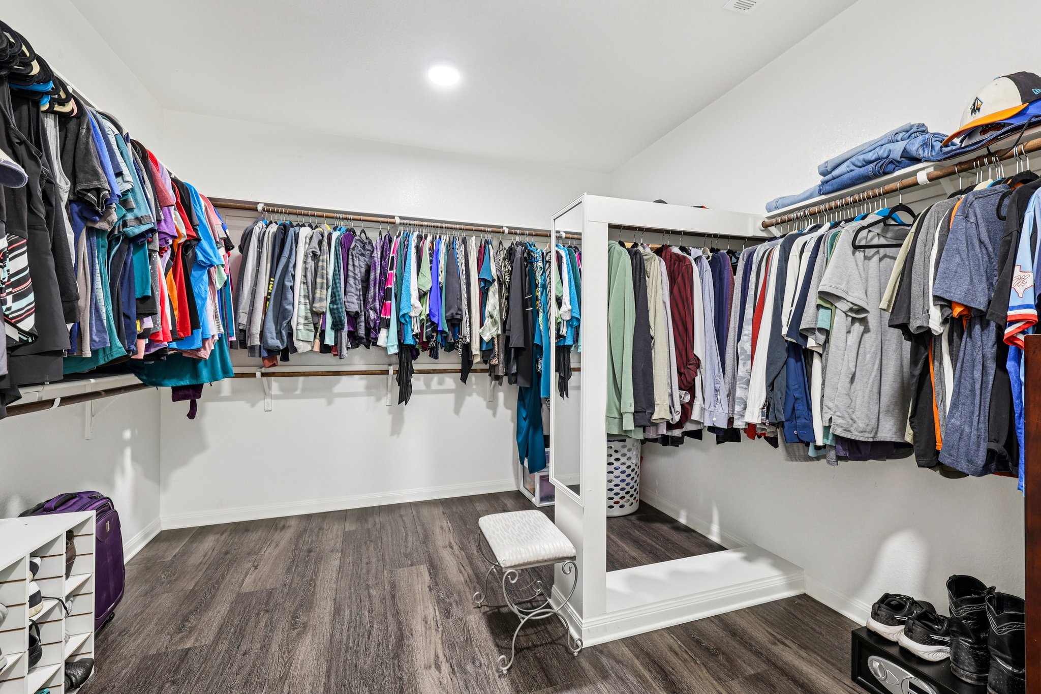 10033 Gertrudis Loop Austin, TX 78747 - Photo 32 of 39 This expansive walk-in closet features dark wood-style flooring, white walls, and built-in hanging rods and shelving for ample storage