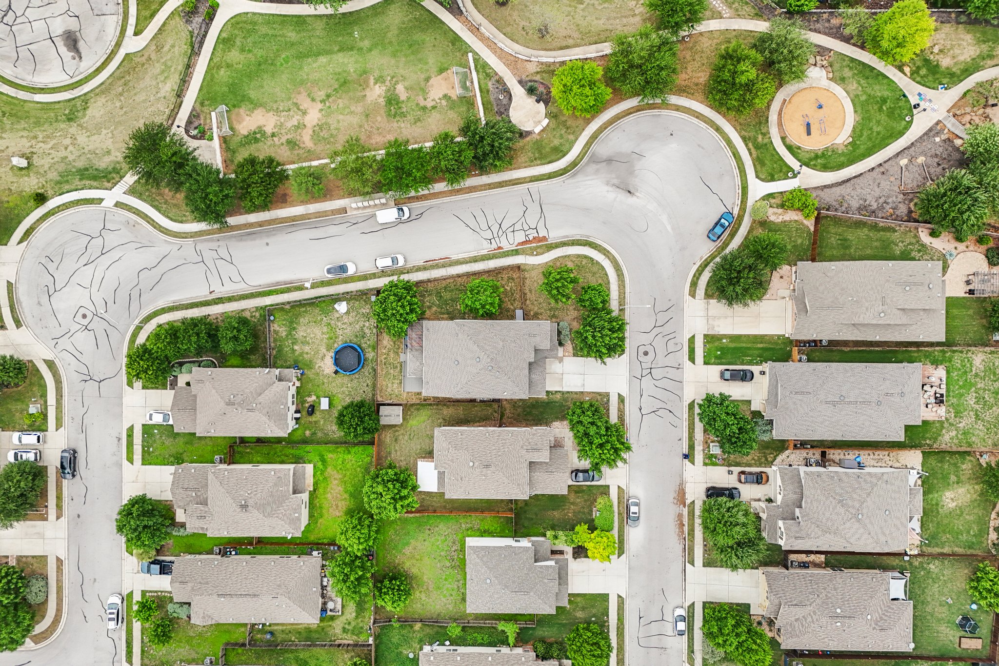 10033 Gertrudis Loop Austin, TX 78747 - Photo 38 of 39 Aerial view showcasing residential properties with gray roofs and green yards, situated along a curved street