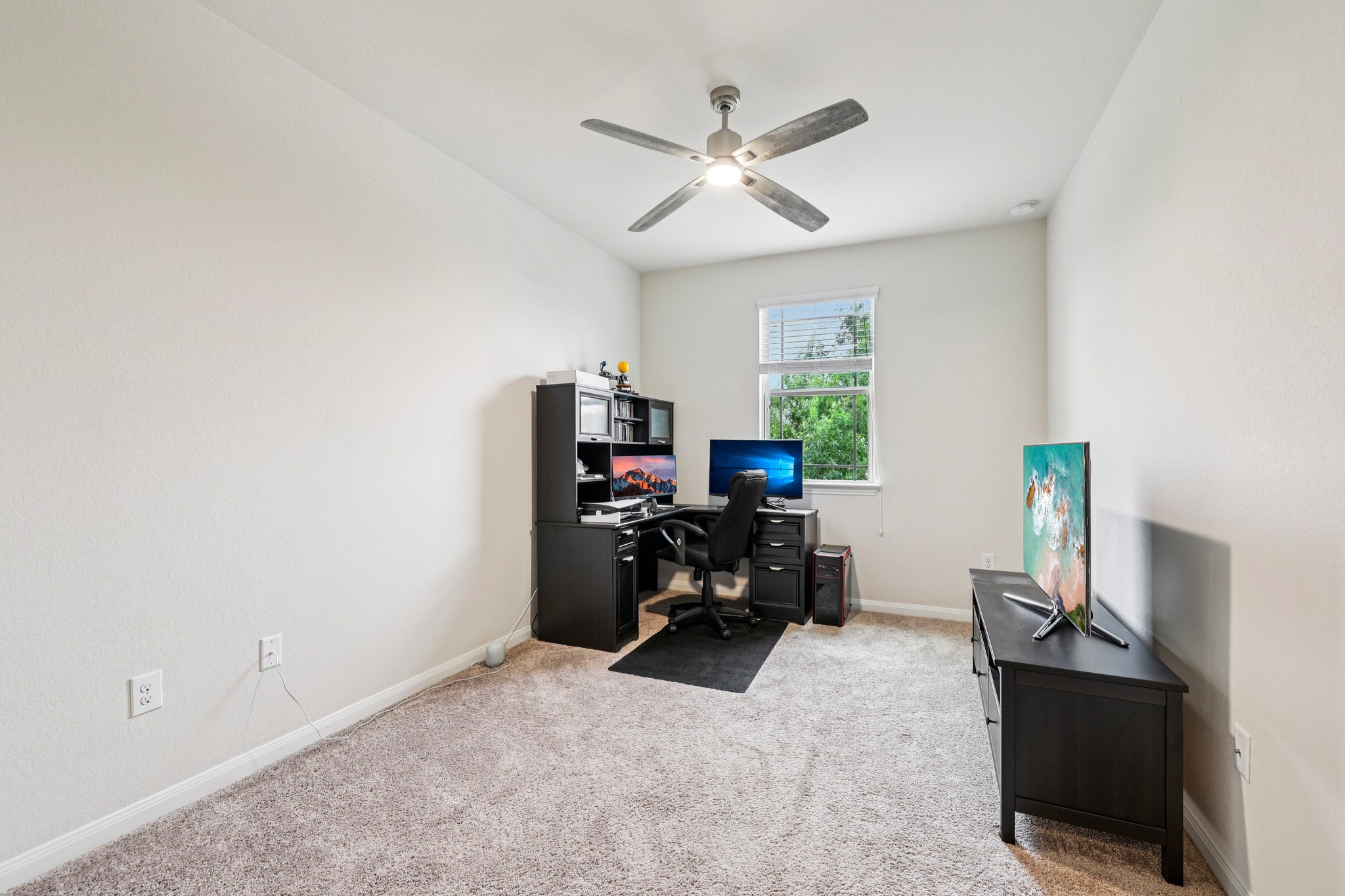 10033 Gertrudis Loop Austin, TX 78747 - Photo 9 of 39 This room features light-colored walls, carpeted flooring, and a ceiling fan with integrated lighting
