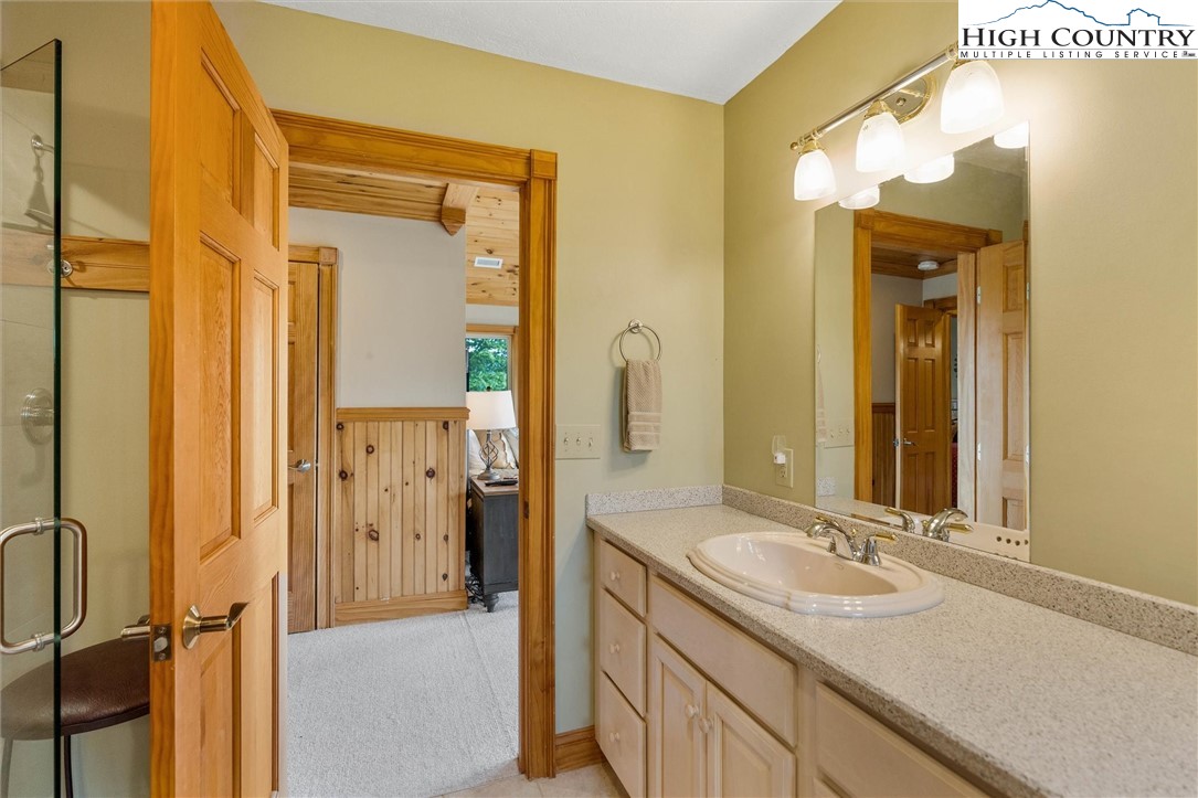 411 West Ridge Drive Ferguson, NC 28624 - Photo 14 of 45 a bathroom with a sink a mirror a vanity and a shower