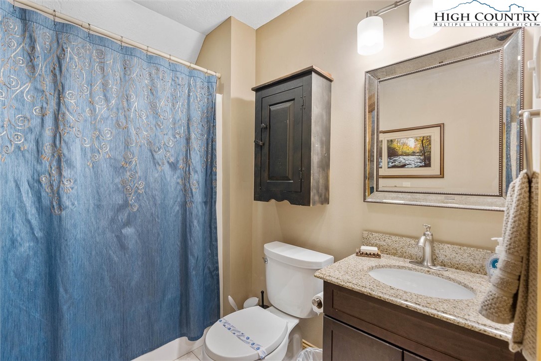 411 West Ridge Drive Ferguson, NC 28624 - Photo 33 of 45 a bathroom with a granite countertop toilet a sink and mirror