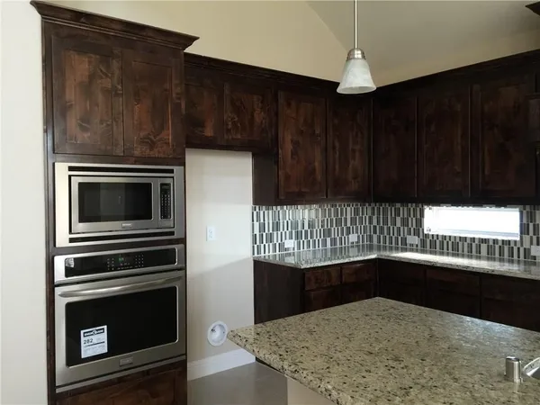 a kitchen with granite countertop wood cabinets and stainless steel appliances