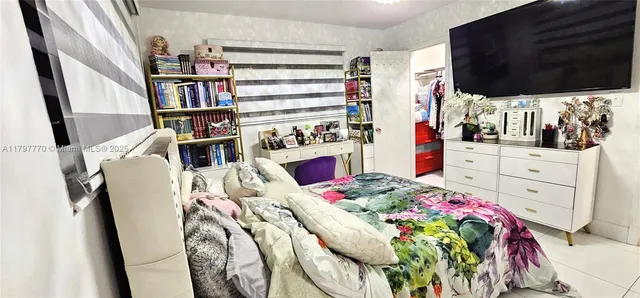 a bedroom with a bed furniture and a flat tv screen