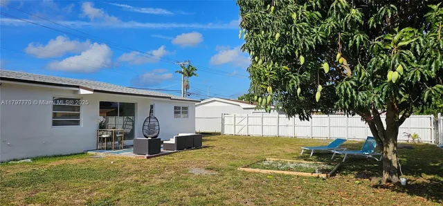 a backyard of a house with table and chairs