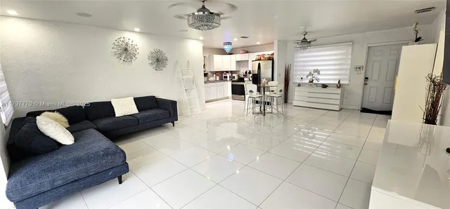 a living room with furniture and a dining table with kitchen view