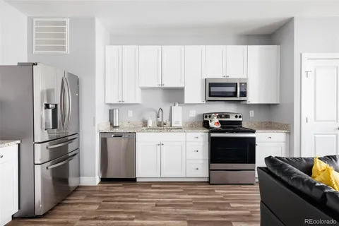 a kitchen with granite countertop a refrigerator stove and microwave