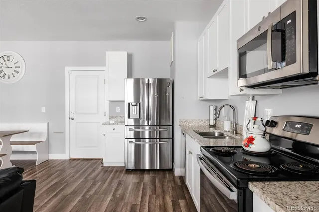a kitchen with stainless steel appliances a stove a sink and a refrigerator