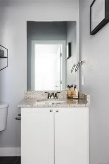 a bathroom with a granite countertop sink and a mirror