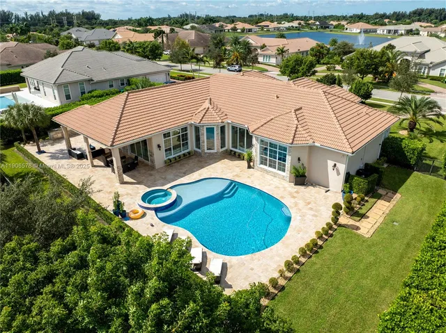an aerial view of a house with swimming pool and mountains