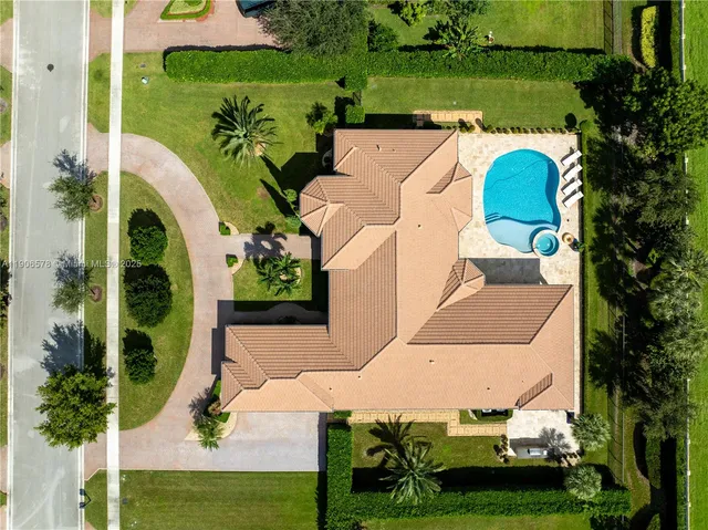 an aerial view of a house with outdoor space swimming pool patio and lake view
