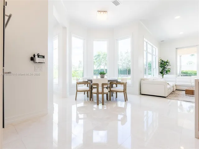 a large living room with stainless steel appliances kitchen island granite countertop a couch and a view of living room