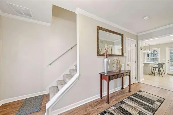 a view of a hallway with wooden floor and staircase