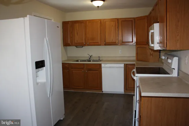 a kitchen with a sink a refrigerator and cabinets