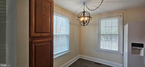 a view of a hallway with wooden floor and chandelier