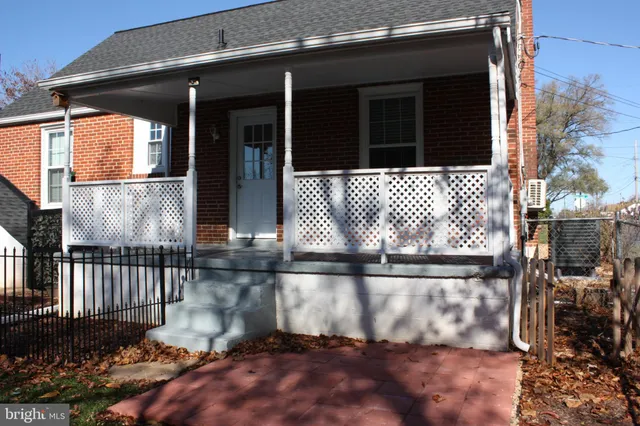 a view of a house with a small yard and wooden floor and fence