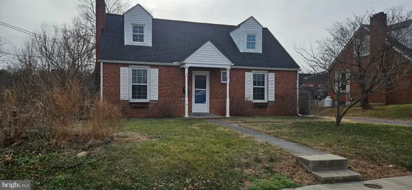 a view of a yard in front of a brick house with large windows