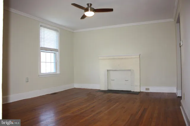 an empty room with a window and wooden floor