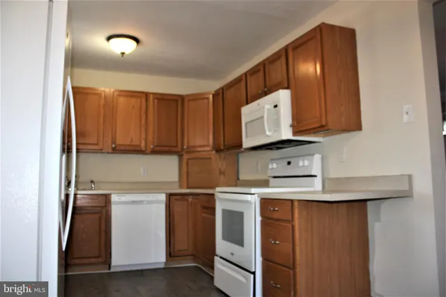a kitchen with white cabinets and white appliances