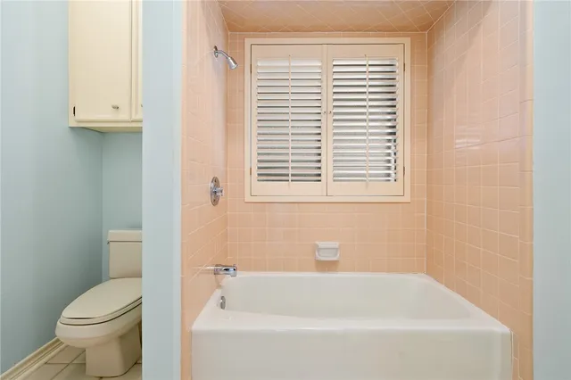 a white bath tub sitting next to a toilet