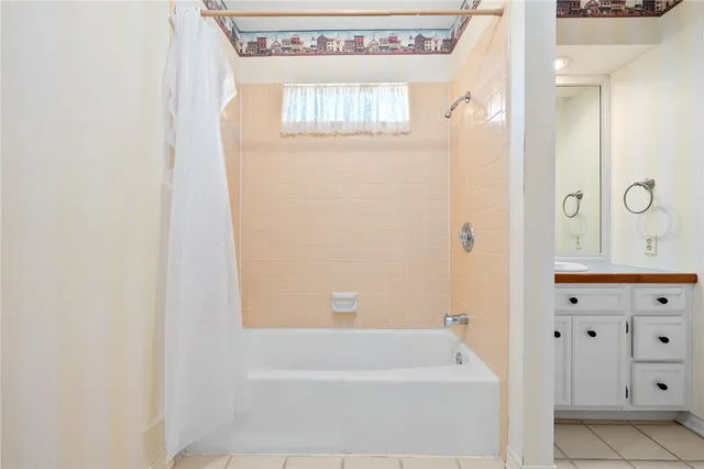 a bathroom with a bathtub a window and a shower