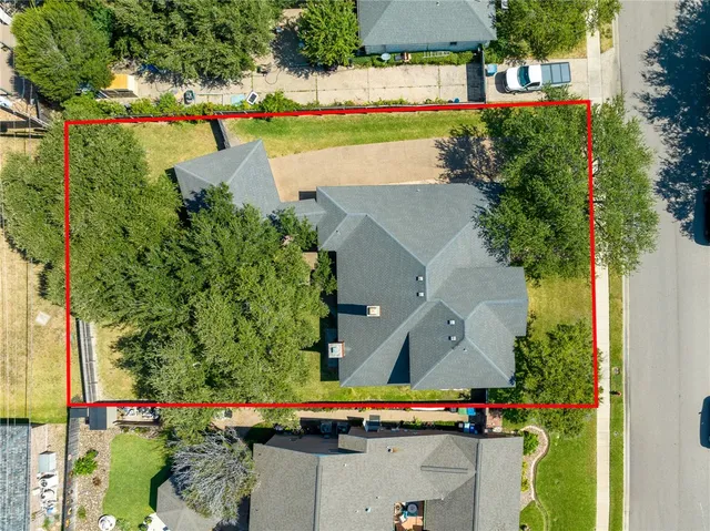 an aerial view of a house with a yard and lake view