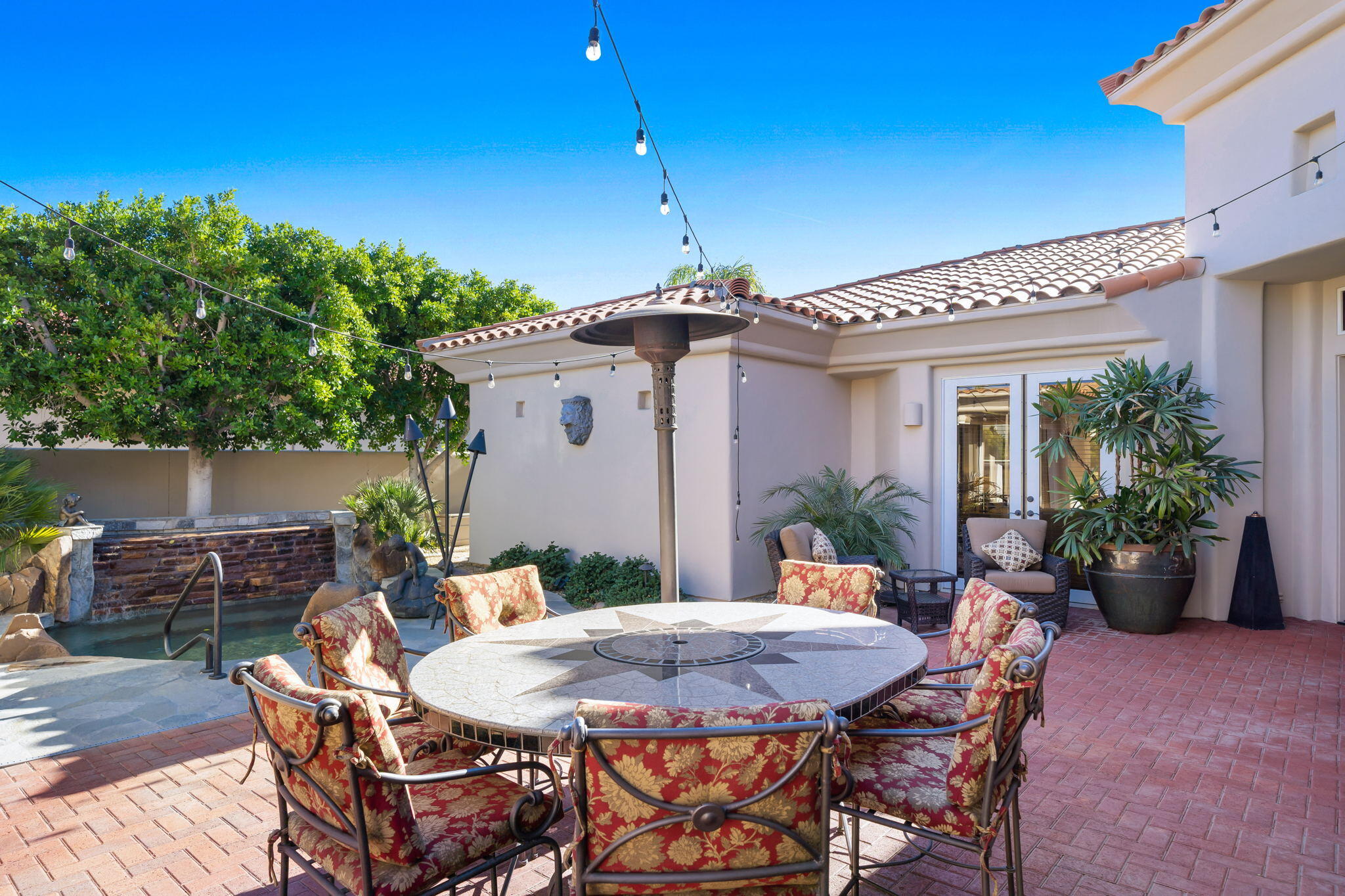 290 Loch Lomond Road Rancho Mirage, CA 92270 - Photo 37 of 50 a patio with table and chairs and potted plants