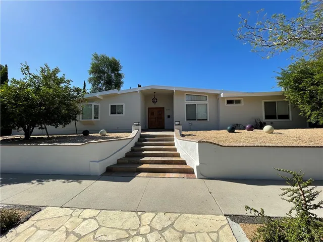 a outdoor space with lots of white walls and plants