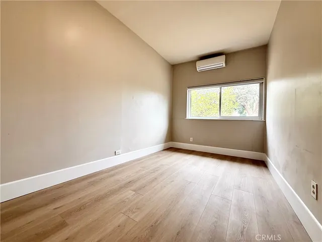 a view of an empty room with a fireplace and a window